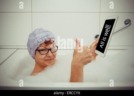 Frau in der Badewanne mit Tablet-Computern nehmen OK, Retro-Stil, Raum für text Stockfoto