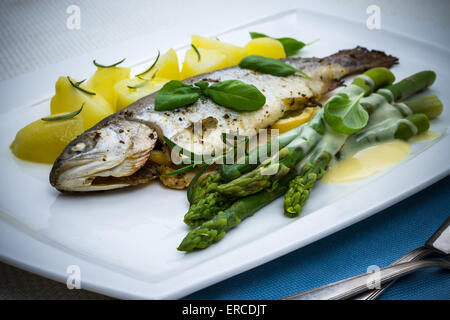 Gegrillte Forelle mit grünem Spargel und Rosmarinkartoffeln, sauce Stockfoto