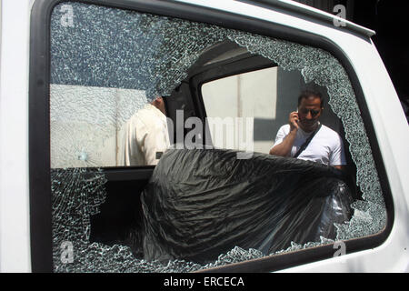 Srinagar, Kaschmir. 1. Juni 2015. Ein Kashmiri reden auf seinem Handy neben dem beschädigten Fenster eines privaten Fahrzeugs nach einer Explosion, kontrolliert indischen Kaschmir. Bildnachweis: Sofi Suhail/Alamy Live-Nachrichten Stockfoto