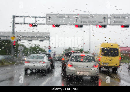 Durch Wassertropfen auf der Windschutzscheibe an Autos im Verkehr gesehen Stockfoto