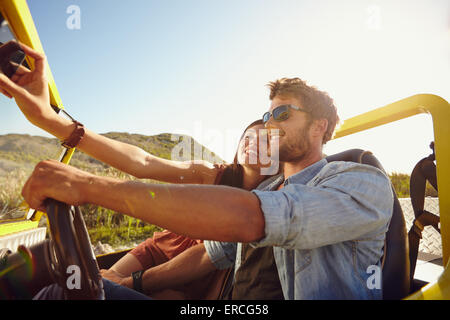 Paar auf Road-Trip, Mann fahren ein Auto und eine Frau nehmen Selfie auf ihr Handy. Stockfoto