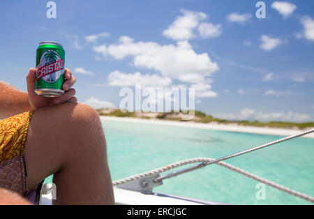 Ein männlichen Touristen Getränke Cristal Beer auf einem Boot im Urlaub in Kuba. Stockfoto