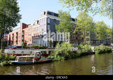 Altes Hausboote mit schwimmenden Gärten an Ecke Nieuwe Achtergracht Kanal und Lepelkruisstraat, Amsterdam, Niederlande Stockfoto