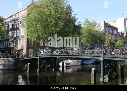 Viele Fahrräder parken auf einer alten gusseisernen Brücke am Nieuwe Achtergracht Kanal, Amsterdam, Niederlande Stockfoto