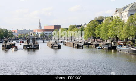 Amstel Fluss mit Blick auf Amstelsluizen & Magere Brug, Stadtzentrum von Amsterdam, Niederlande. Royal Theater Carré rechts Stockfoto