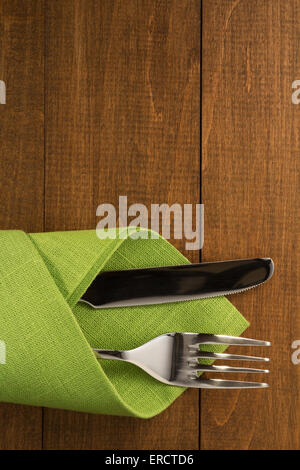 Messer und Gabel auf Serviette auf hölzernen Hintergrund Stockfoto