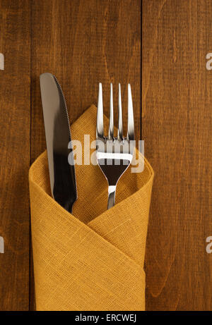 Messer und Gabel auf Serviette auf hölzernen Hintergrund Stockfoto