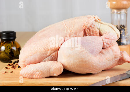 Ganze rohe Huhn auf einem Holzbrett Stockfoto