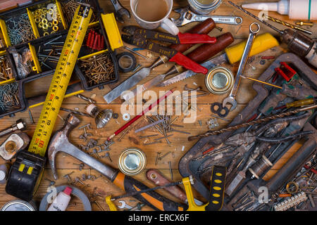 Pflege zu Hause - eine unordentliche Werkbank voller staubigen alten Werkzeuge und Schrauben. Stockfoto