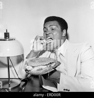 Muhammad Ali der Louisville Lippe zum Schweigen gebracht durch einen Stottie Kuchen, eine traditionelle Geordie Delikatesse gefüllt mit Salat, Zwiebeln, Gurken und Tomaten. Fotografieren während seiner Tour von Tyneside Newcastle. 16. Juli 1977 Stockfoto