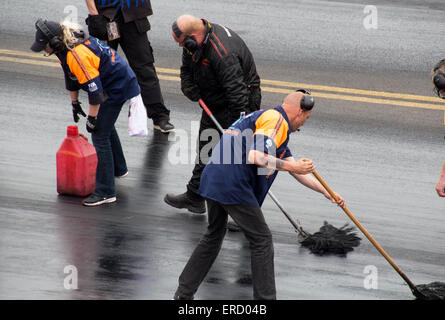 Reinigung der Rennstrecke nach einem verschütten beim Santa Pod FIA Main Event Mai 2015 Stockfoto