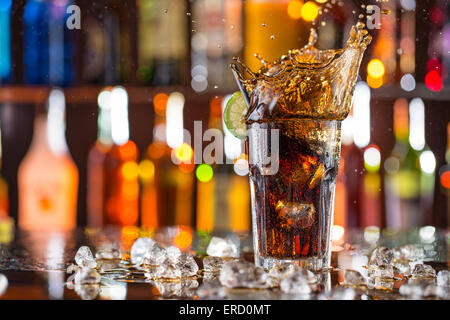 Glas Cola auf bar Schreibtisch mit Spritzer flüssigen, Nahaufnahme. Stockfoto