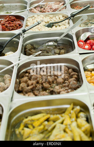 Dokumentarische Essen Bild von eingelegtem Knoblauch, Tintenfisch, Tapas-Küche zu verkaufen in Containern auf einem Deli-Stand an Matlock Markt Stockfoto