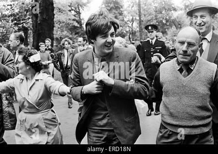 Paul McCartney von den Beatles ist vorbei an wartenden Fans begleitet, als er in den ABC Studios in Teddington, Middlesex, vor der Live-Auftritt auf ABC kommt-TV Lucky Stars (Sommer Spin), Samstag, 11. Juli 1964. Die Beatles überquert die Themse auf einem Boot zu Stockfoto