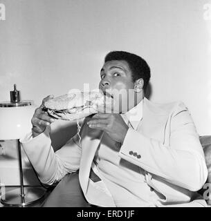 Muhammad Ali der Louisville Lippe zum Schweigen gebracht durch einen Stottie Kuchen, eine traditionelle Geordie Delikatesse gefüllt mit Salat, Zwiebeln, Gurken und Tomaten. Fotografieren während seiner Tour von Tyneside Newcastle. 16. Juli 1977 Stockfoto