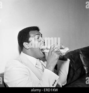 Muhammad Ali der Louisville Lippe zum Schweigen gebracht durch einen Stottie Kuchen, eine traditionelle Geordie Delikatesse gefüllt mit Salat, Zwiebeln, Gurken und Tomaten. Fotografieren während seiner Tour von Tyneside Newcastle. 16. Juli 1977 Stockfoto