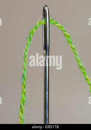 Nahaufnahme der Wolle durch das Auge einer Stopfnadel eingefädelt. Stockfoto