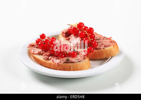 Brotscheiben mit Leberpastete und rote Johannisbeeren Stockfoto