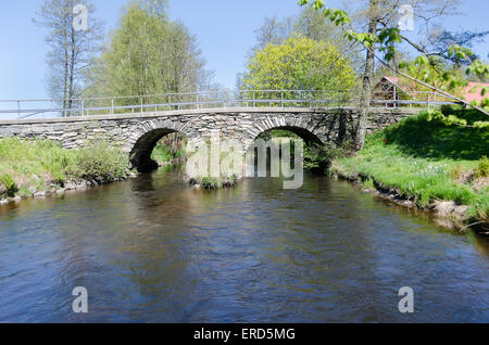 alten Stonebridge über das kalte Wasser eines sonnigen Tages im zeitigen Frühjahr Stockfoto