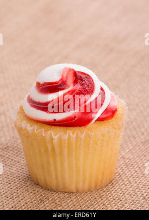 Erdbeere aromatisierte swirly Top Cupcake auf einfache Sackleinen Hintergrund Stockfoto