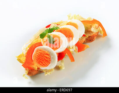 Knusprige Brötchen mit gekochtem Ei, Paprika und Salat Stockfoto