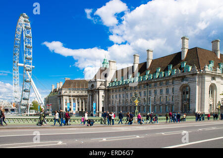 Millennium Eye und London County Hall. Sonniges Wetter, Touristen auf der Straße. Stockfoto