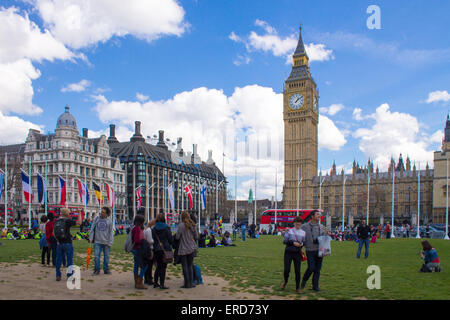 Massen, die sitzen auf dem Rasen in Parliament Square, London. Sonniges Wetter. Stockfoto