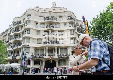 Paar ältere Touristen überprüfen eine Map gegenüber Casa Milà (La Pedrera genannt) von Antoni Gaudí, 92, Passeig de Gràcia, befind Stockfoto