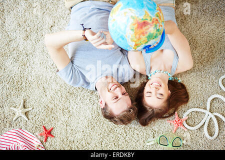 Junges Paar mit Erde Modell auf dem Boden liegend Stockfoto