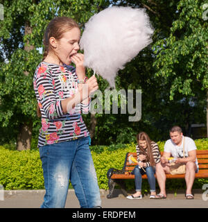 junges Mädchen essen Zuckerwatte im Stadtpark Stockfoto