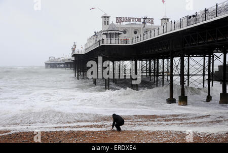 Brighton, UK. 2. Juni 2015. Eine einsame Gestalt Spaziergänge am Strand von Brighton Pier heute morgen was kaum sein kann "Flaming Juni" genannt, da Stürme der South Coast of Britain Peitschen Stockfoto