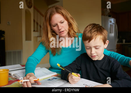 Kaukasische Mutter hilft Sohn machen Hausaufgaben Stockfoto