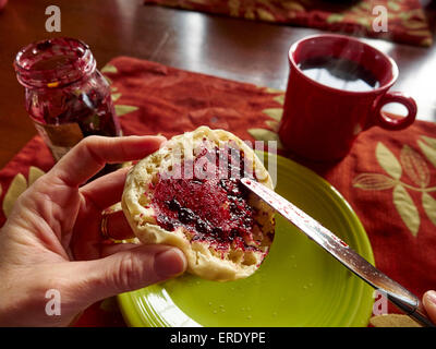 Kaukasische junge Verbreitung Marmelade auf Englisch muffin Stockfoto