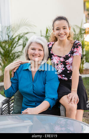 Ältere Großmutter und Enkelin lächelnd in Hinterhof Stockfoto