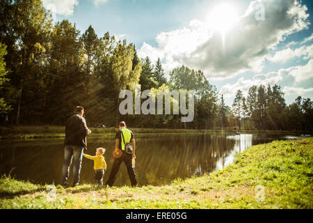 Kaukasische Vater und Söhne spielen in der Nähe von Park-Teich Stockfoto