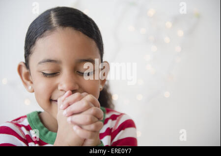 Nahaufnahme von Mischlinge Mädchen beten zu Weihnachten Stockfoto