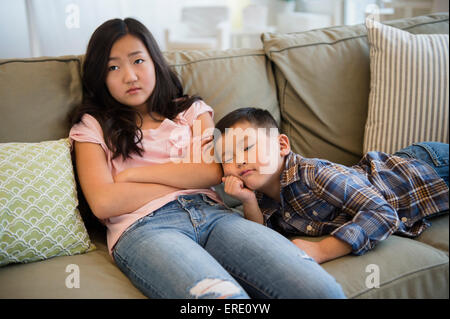 Gelangweilt asiatische Bruder und Schwester entspannend auf sofa Stockfoto