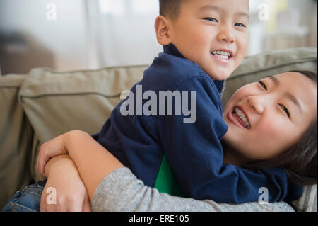 Asiatische Bruder und Schwester spielen auf sofa Stockfoto