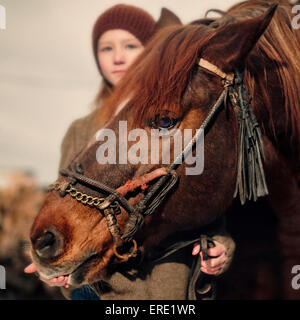 Kaukasische Mädchen hält die Zügel des Pferdes Stockfoto