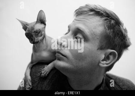 Haarlose Katze sitzt auf der Schulter des kaukasischen Mann Stockfoto