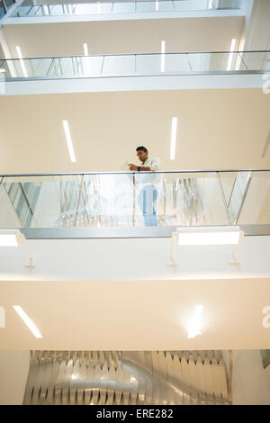 Asiatische Geschäftsmann stehend auf Balkon des Bürogebäudes Stockfoto