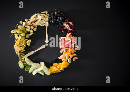 Uhr mit Obst, Gemüse und Besteck aus Stockfoto