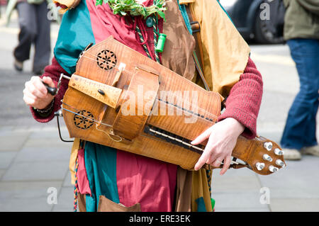 Frau spielt eine Drehleier Gurdy in ausgefallenen Kostüm, die Teilnahme an der St. Georges Day Feierlichkeiten in der Stadt-Zentrum-Marktplatz, Stockfoto