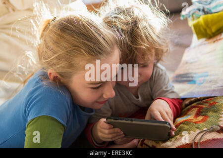 Kaukasische Bruder und Schwester mit Handy auf sofa Stockfoto