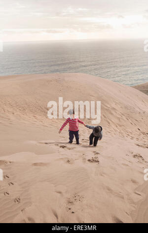 Hispano-Amerikaner Brüder Klettern auf Sanddünen am Strand Stockfoto