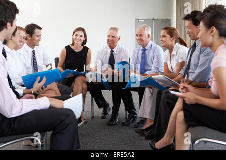 Geschäftsleute, die sitzen im Kreis auf Firmenseminar Stockfoto