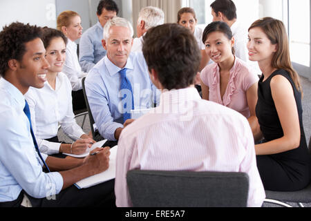 Geschäftsleute, die sitzen im Kreis auf Firmenseminar Stockfoto