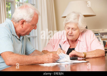 Älteres paar besorgt über Schulden durch Rechnungen zusammen gehen Stockfoto