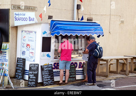 Kauf von Meeresfrüchten an einem Stand an Ozon Terrasse in Lyme Regis auf der Jurassic Coast, Dorset, England, UK Stockfoto