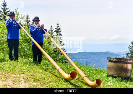 Traditionelle Musiker spielen cor des Alpes (Alphorn) in der Schweiz Stockfoto